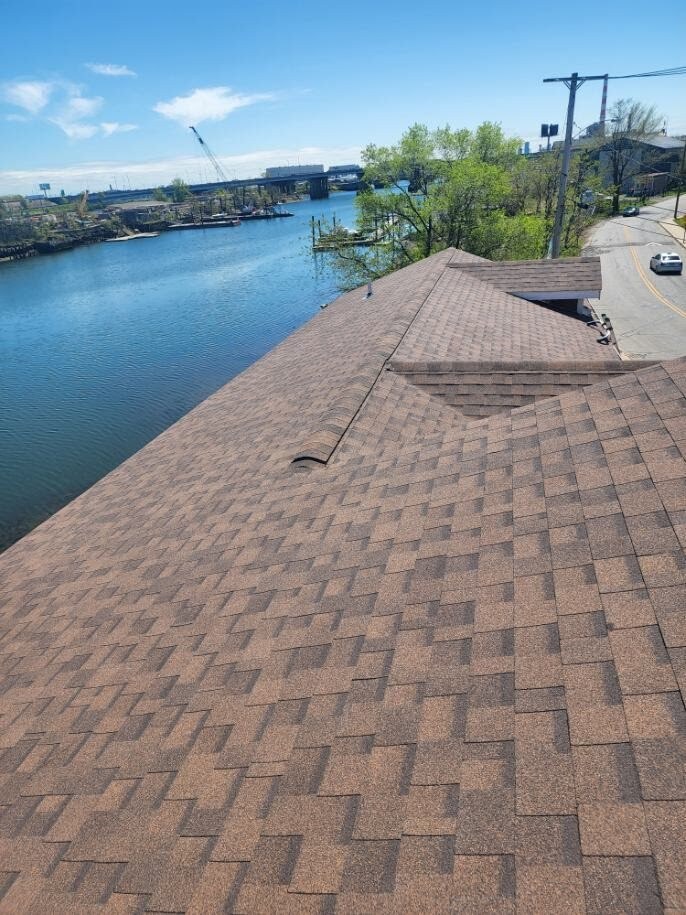 A finished brown shingle roof above the water