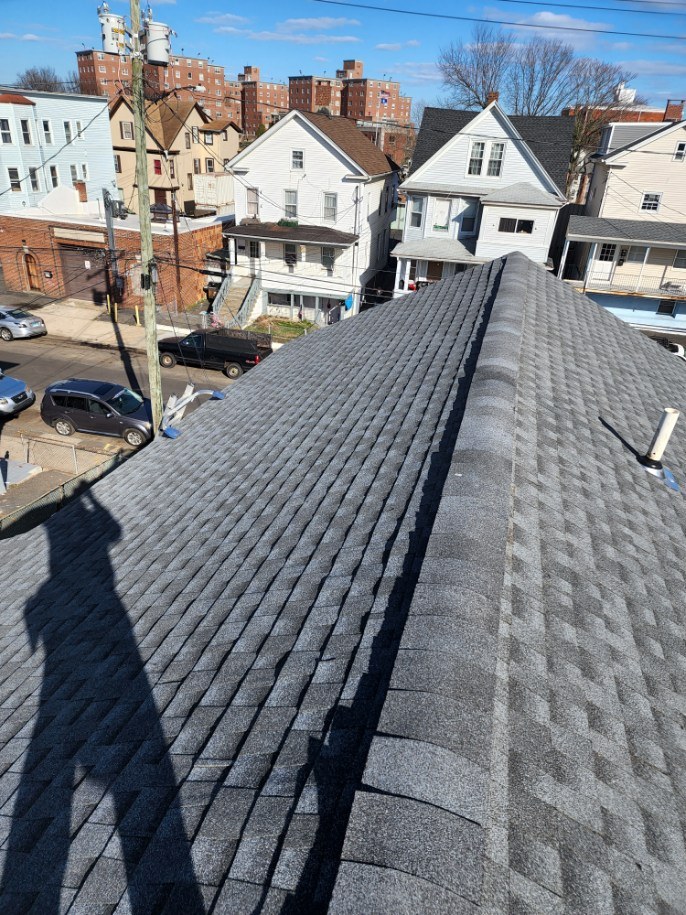 A long dark shingle roof in a Connecticut neighborhood